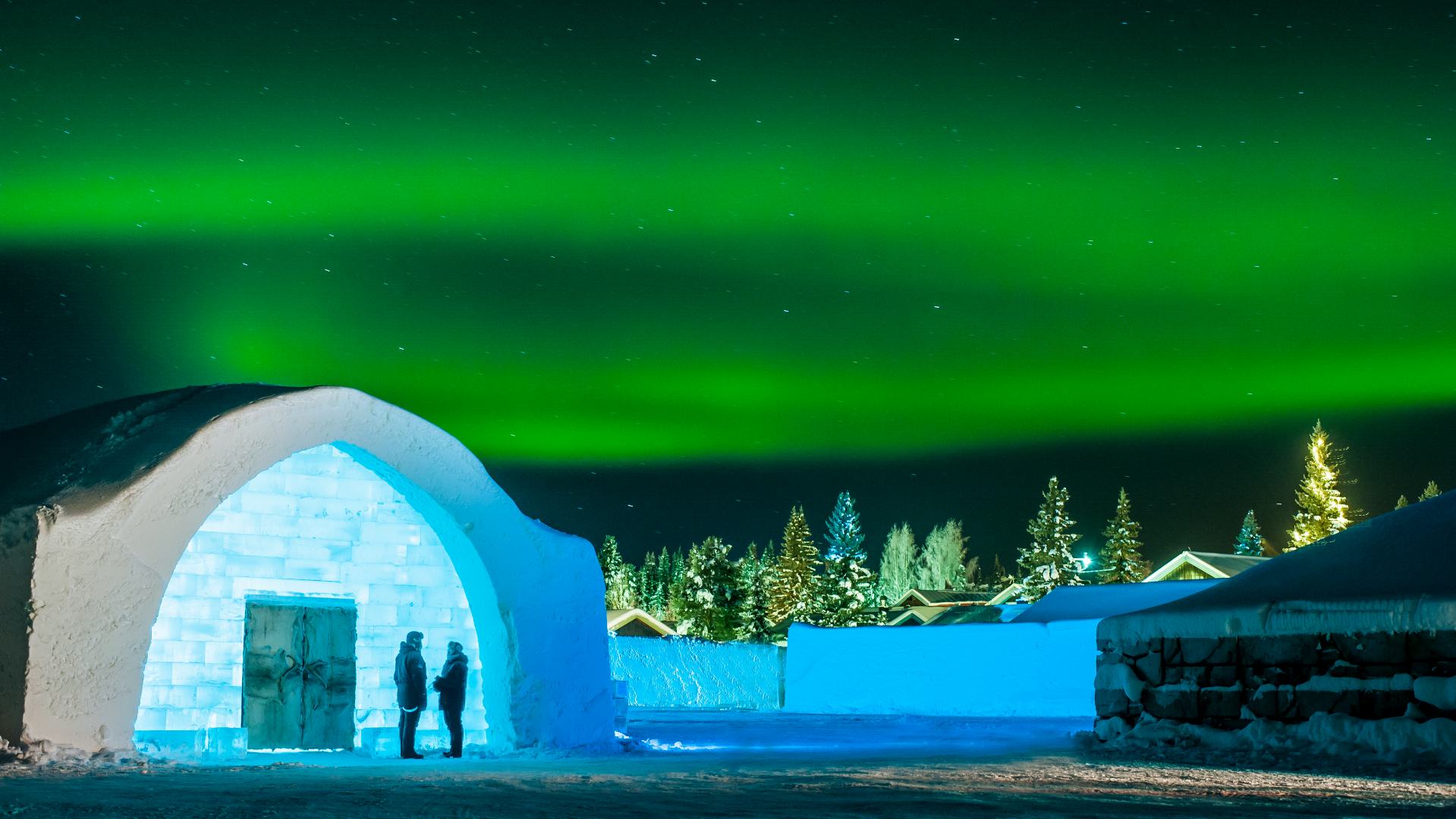 gr&oslash;nt nordlys over icehotel i svensk lapland
