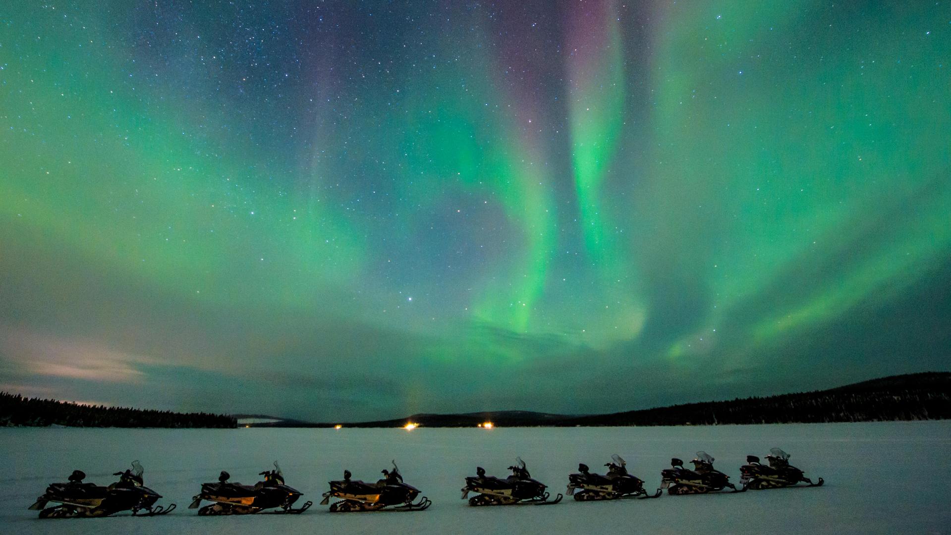 gr&oslash;nt nordlys over snescooterudflugte icehotel i svensk lapland