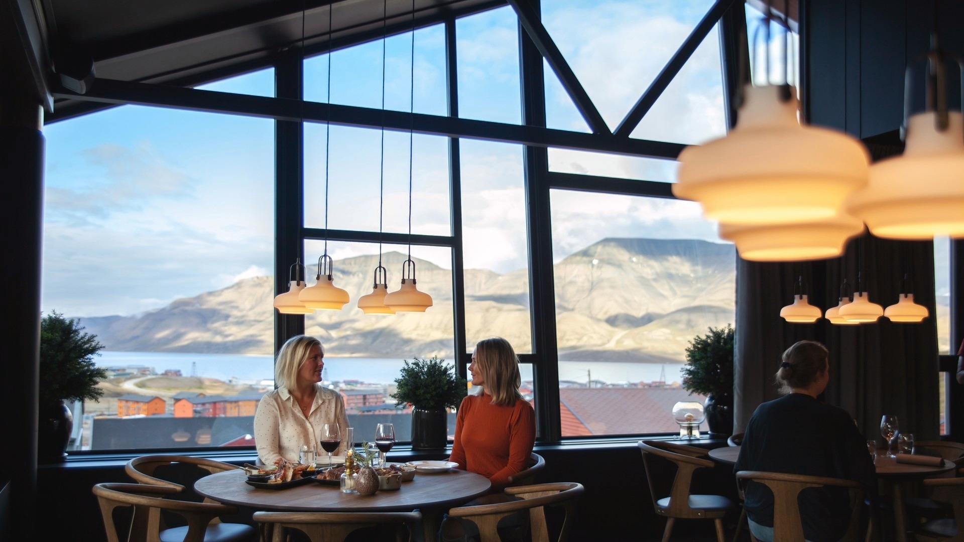 to kvinder i restauranten med udsigt til hvidklædte bjerge